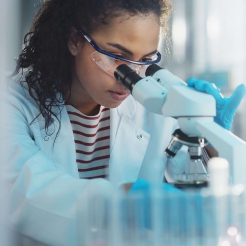 A woman looking through a microscope