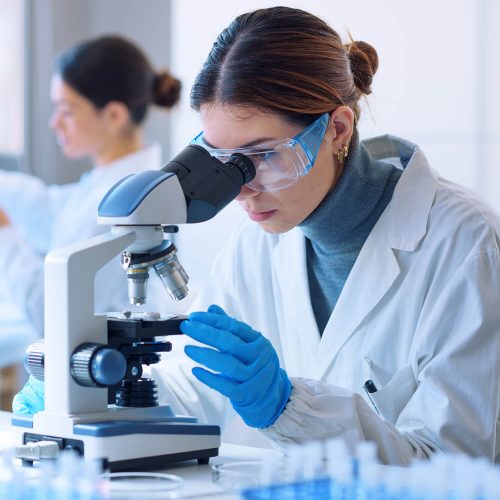 A woman looking through a microscope